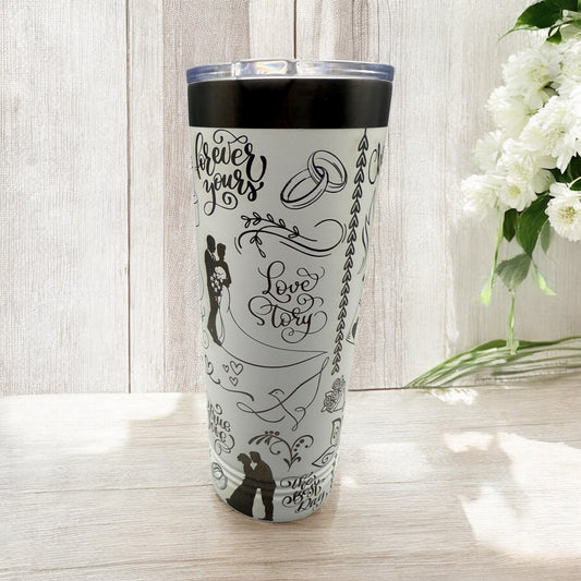 Tumbler with 'Forever Yours Love Story' design on a wooden surface with flowers in the background