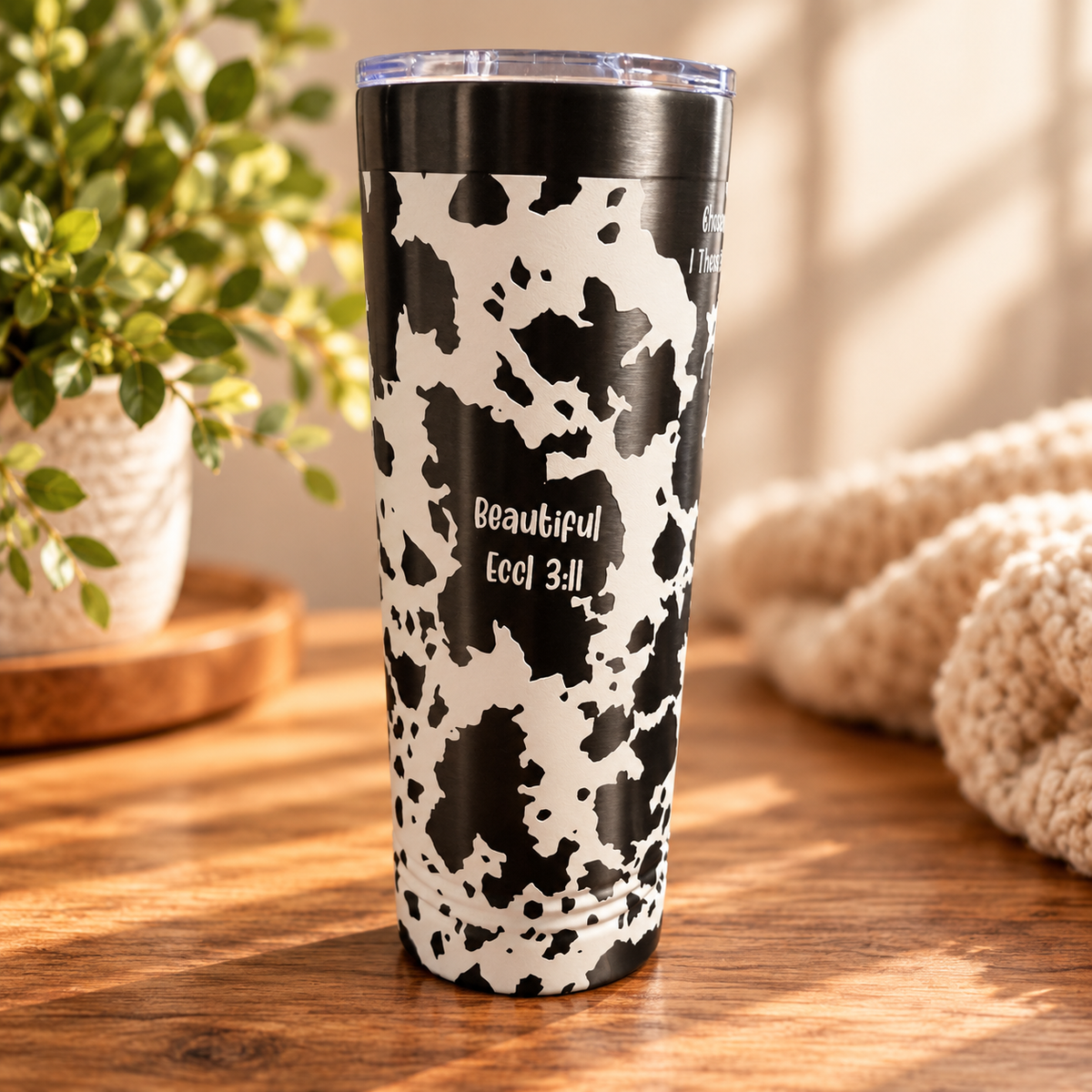 Close-up of cow print tumbler design and scripture engraving
