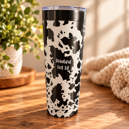 Close-up of cow print tumbler design and scripture engraving
